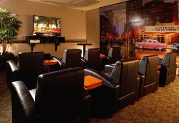 a living room with leather chairs and a tv